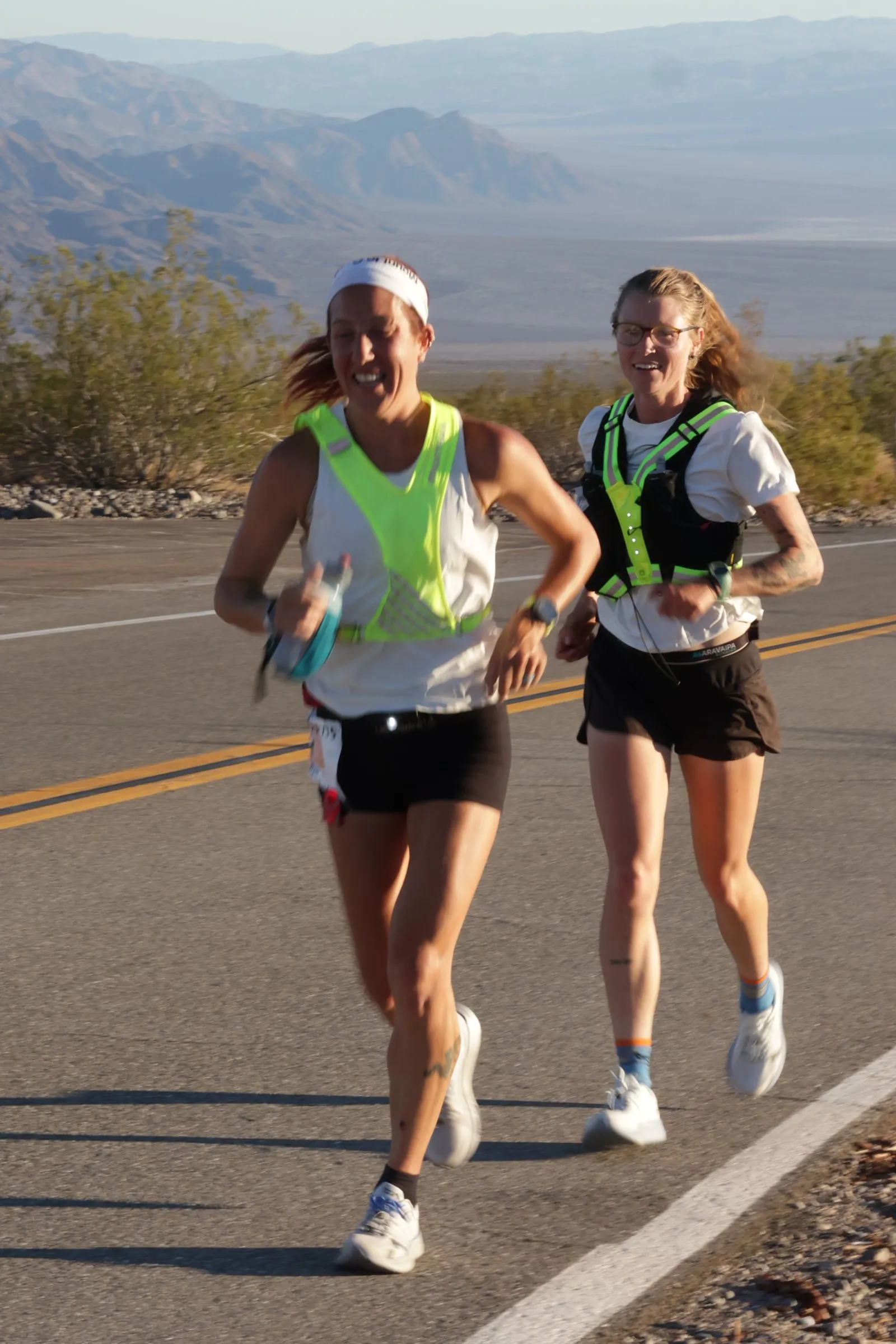 Megan Eckert and a pacer running a desert highway at sunrise at Badwater 135