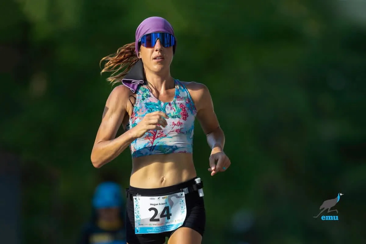 Megan Eckert, bib 24, racing in a floral top and purple headband at the EMU 6-Day Race in Hungary